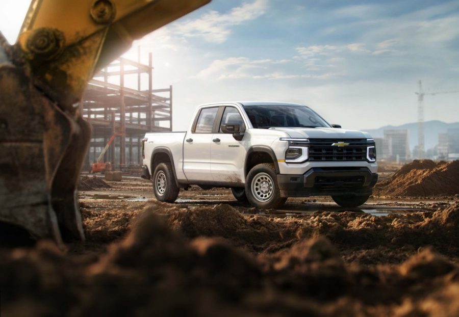 White Chevrolet Silverado 1500 pickup truck on construction site with excavator