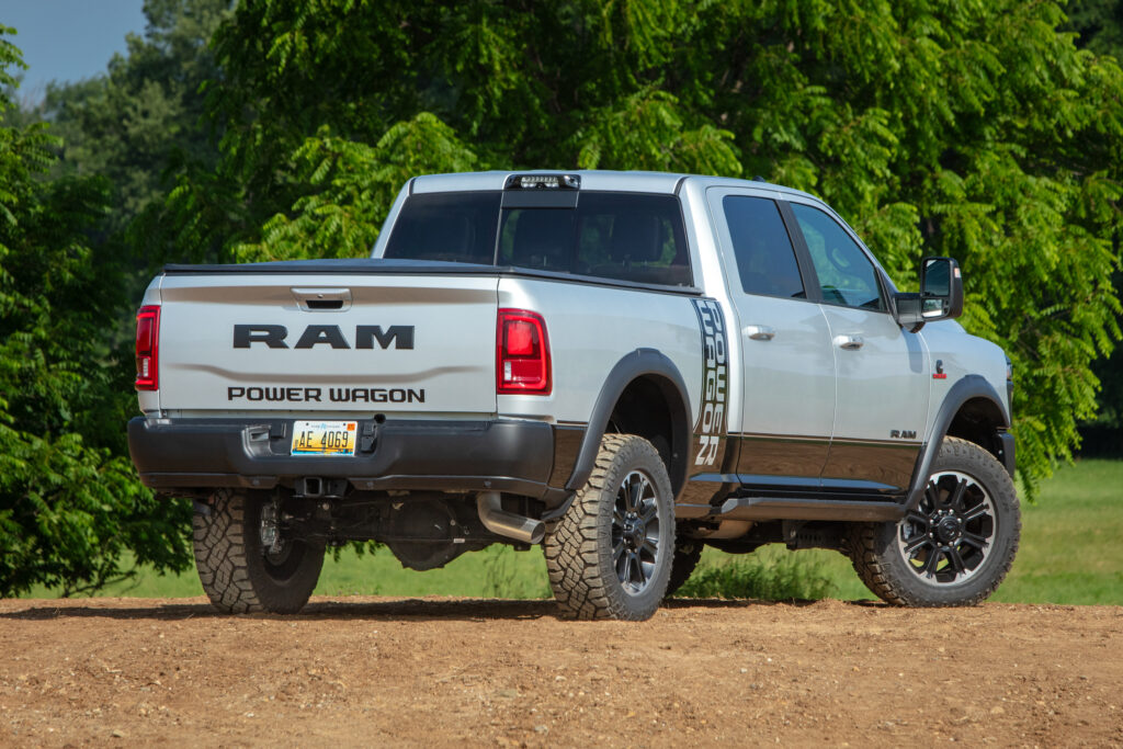 White and brown Ram Power Wagon pickup truck parked on dirt road with trees