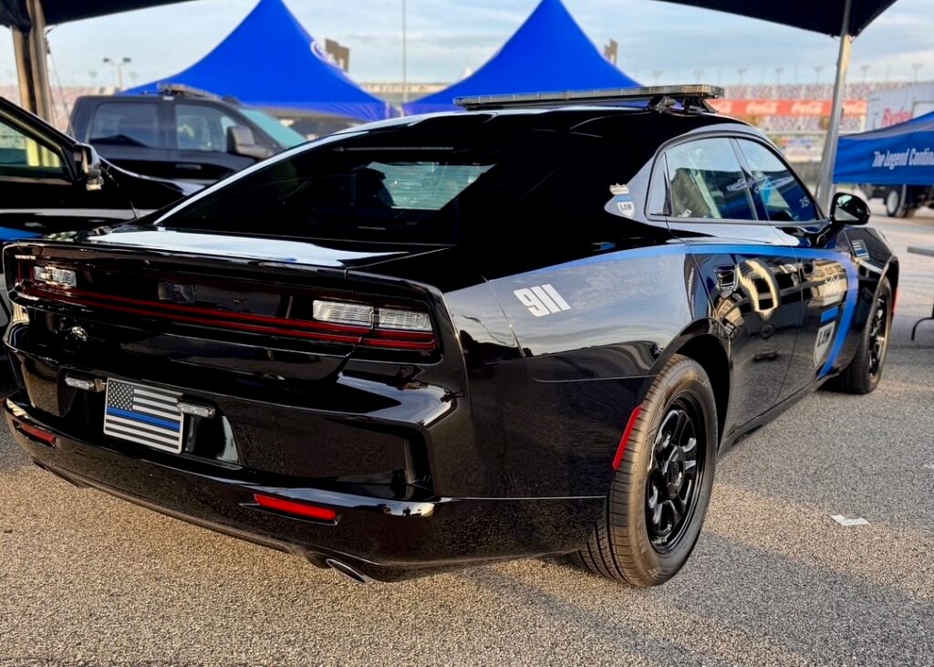 Rear three-quarter view of the black Dodge Charger PPV prototype with a thin blue line flag plate and 911 decal.