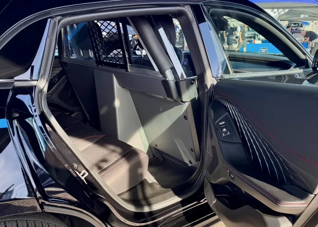 Open rear door of the Dodge Charger PPV prototype showing a police partition and cloth rear bench seat.