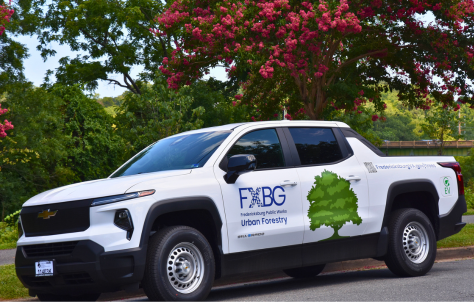 White Chevrolet electric pickup truck with FADO branding and green tree graphic on door