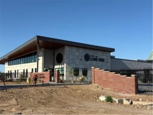 The City of Lone Tree public works building nearing completion, with construction workers in high-visibility vests out front