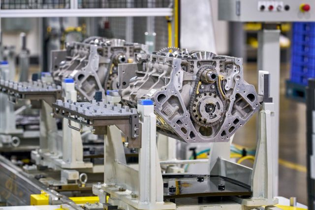 Engine assembly mounted on white fixture in automotive manufacturing facility