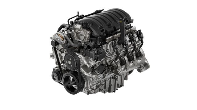Cutaway view of a multi-cylinder automotive engine with intake manifold and accessory components