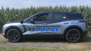 Ferguson Township Police electric patrol vehicle parked beside cornfield