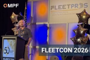 Man speaking at podium during FleetCon 2026 conference with branded backdrop
