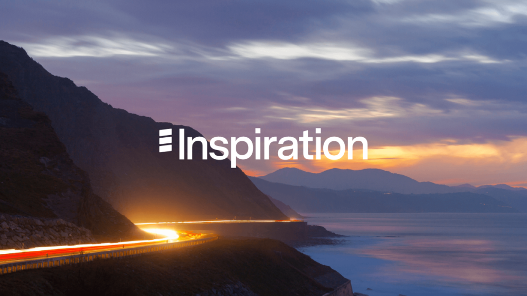Inspiration wordmark overlaid on coastal mountain landscape at sunset with vehicle light trail