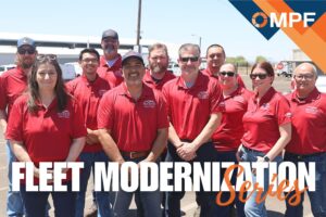 Team of fleet workers in red polo shirts posing outdoors near vehicles