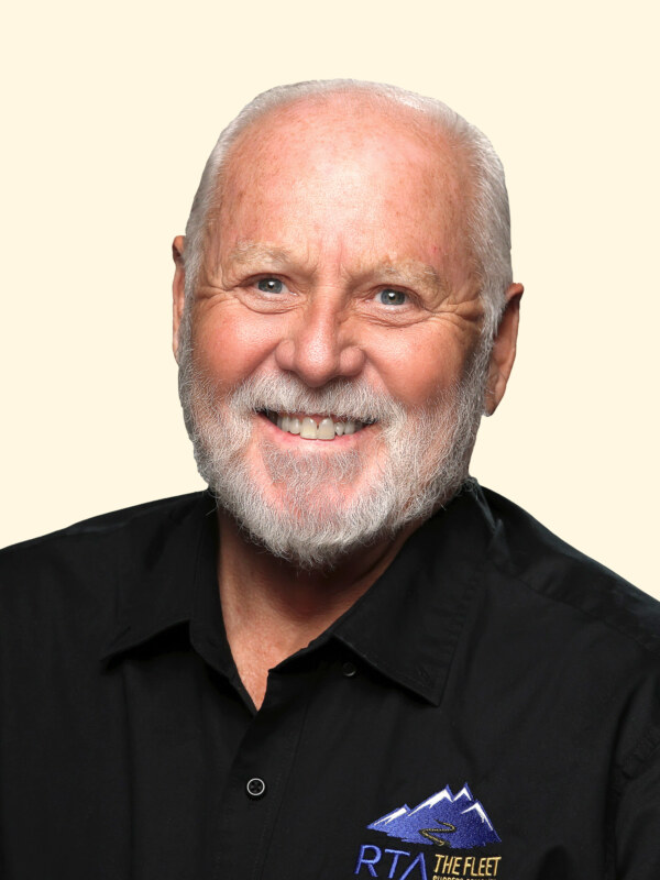 Headshot of older man with gray hair and beard wearing black polo shirt with RTA The Fleet logo