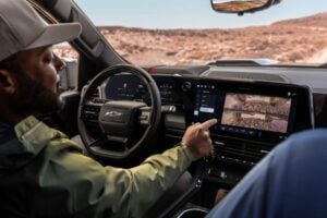 Driver in Chevrolet truck reviews terrain footage on touchscreen display in desert landscape