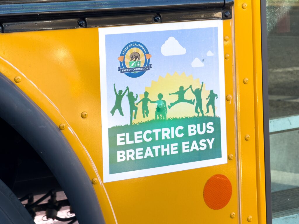 Yellow school bus with "Electric Bus Breathe Easy" decal and California Energy Commission seal