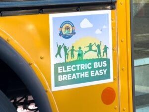 Yellow school bus with "Electric Bus Breathe Easy" decal and California Energy Commission seal