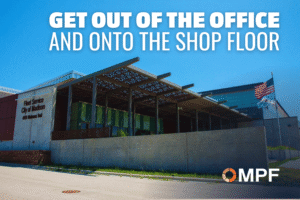 Industrial facility with metal canopy structure and American flag, OMPF logo visible
