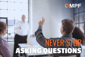 Business professionals in modern office raise hand during presentation with motivational text overlay