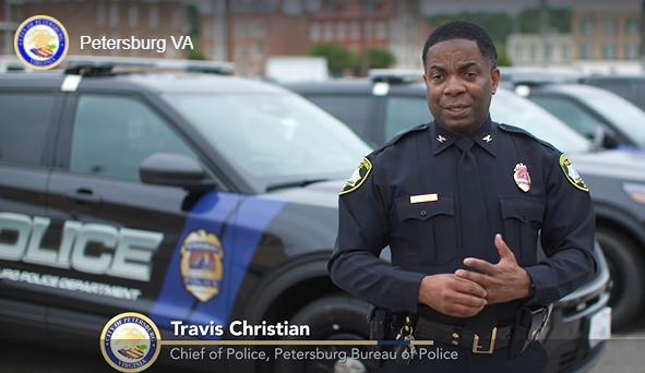 Travis Christian, Chief of Police for Petersburg Bureau of Police, stands before police vehicles