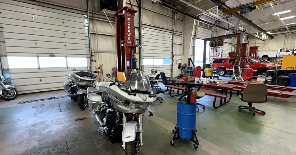 Police motorcycles and a mobile column lift in a service bay at the City of Aurora fleet shop