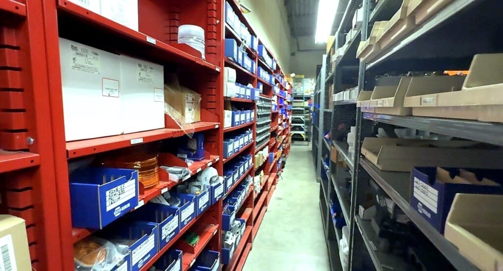 A long aisle of red and gray parts shelving in the City of Aurora fleet parts room
