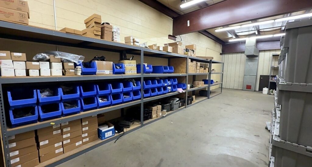 Steel shelving with blue bins and boxed parts in a City of Aurora fleet storage room
