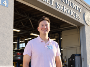 Man in light purple polo shirt standing in industrial warehouse setting