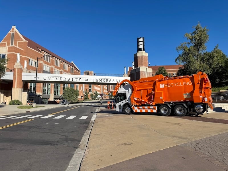 Orange recycling truck parked on University of Tennessee campus street