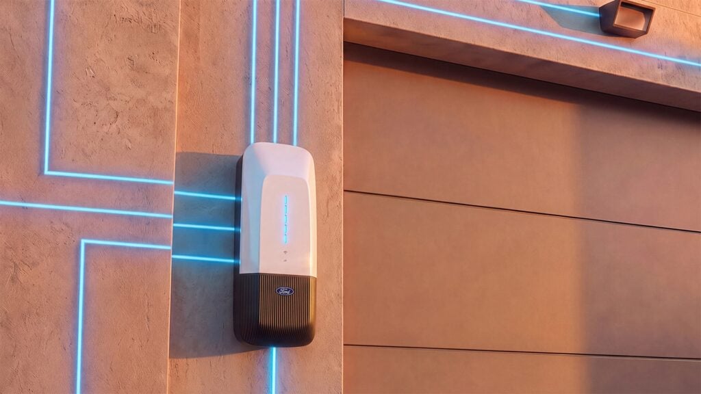 White and black wall-mounted charging device on terracotta brick exterior with blue neon trim lines