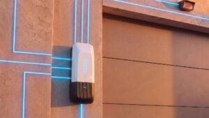 White and black wall-mounted charging device on terracotta brick exterior with blue neon trim lines