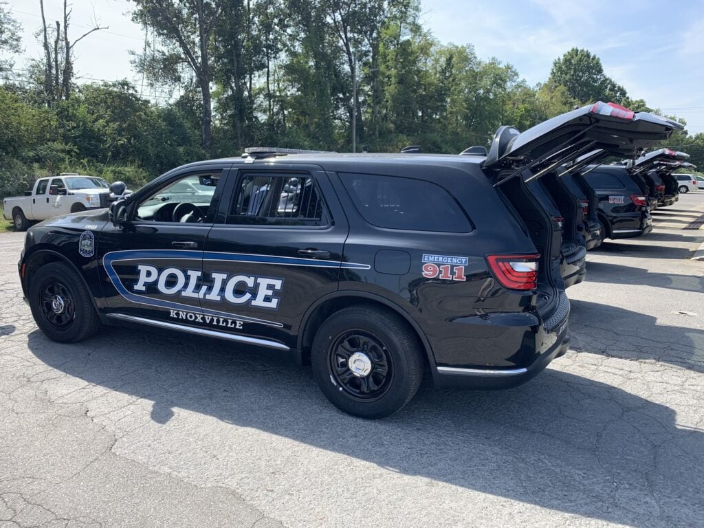 A marked Knoxville Police Dodge Durango with more units behind it, liftgates open