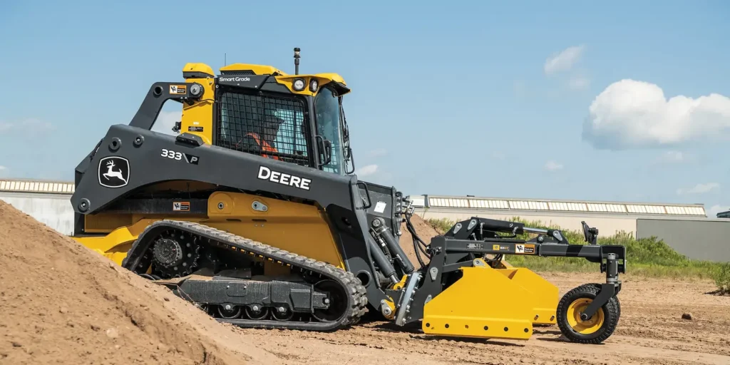 John Deere compact track loader with yellow box blade attachment on dirt site