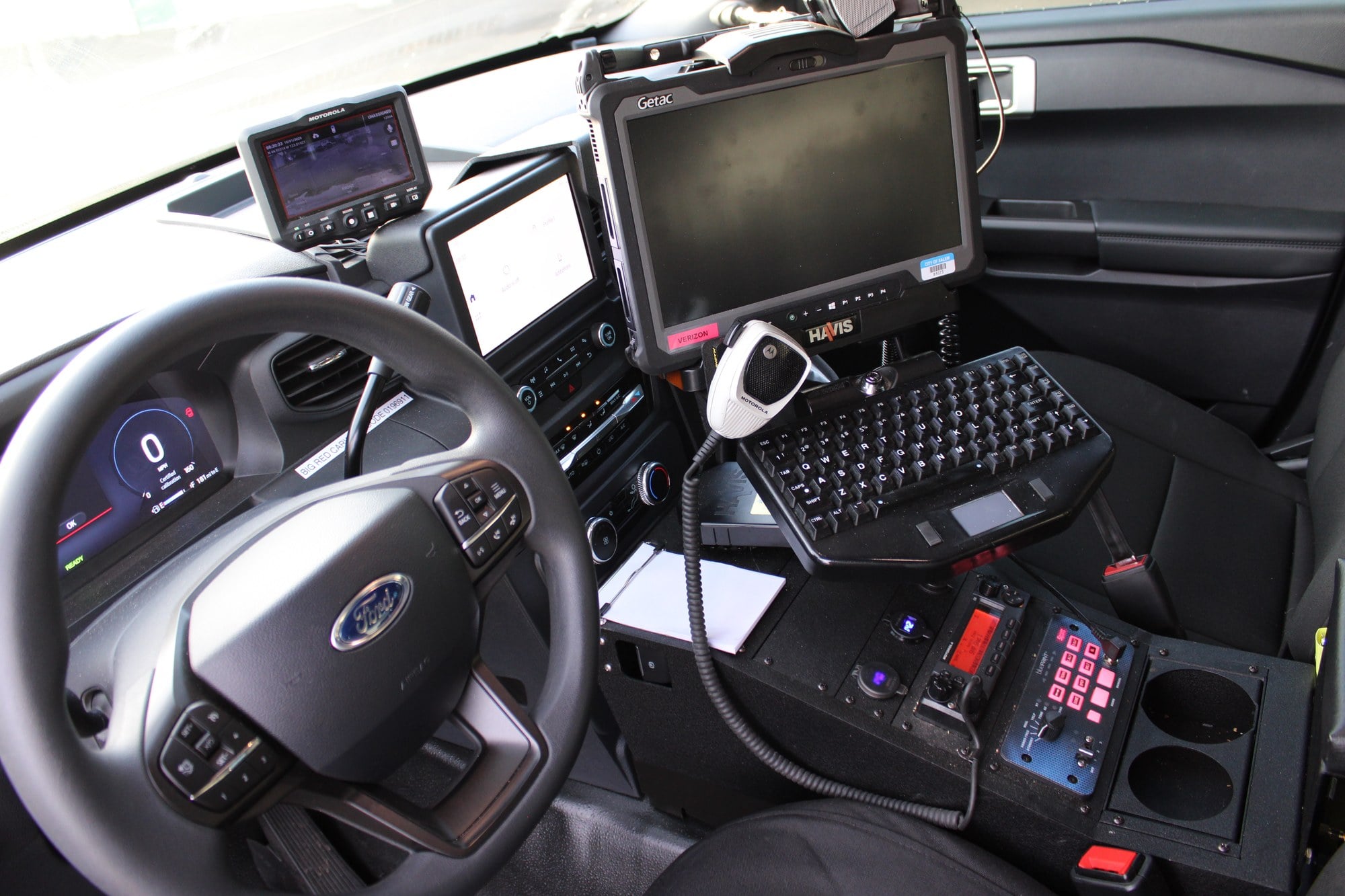 Front-seat workspace of a Salem patrol vehicle with mounted computer, keyboard, radio and control panel