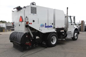 White Avalanche brand street sweeper truck with black brush attachment, parked in lot