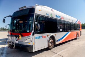 White and orange metrobus transit bus parked outdoors in daylight